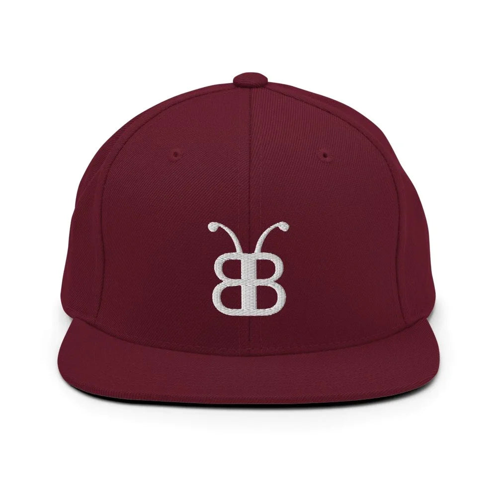 Burgundy snapback cap with white embroidered logo, streetwear style