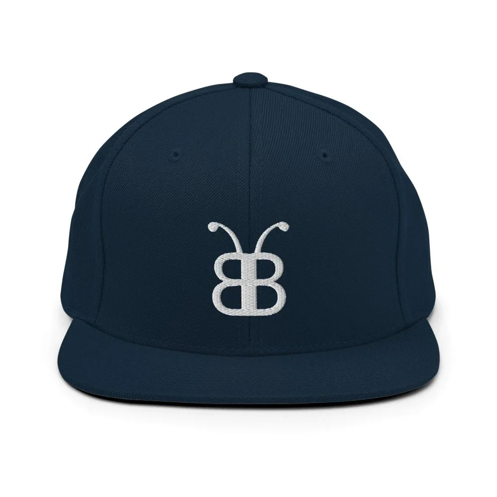 Navy blue snapback cap with white embroidered logo, streetwear style