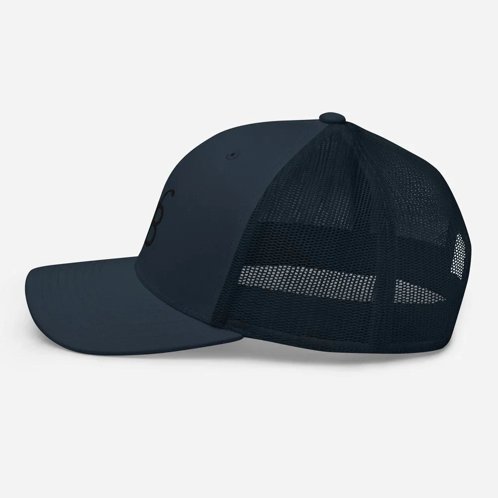 Dark navy trucker hat with mesh back and subtle logo, streetwear style
